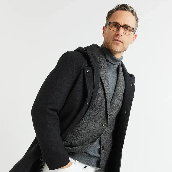 Conjunto de abrigo oscuro, americana gris y jersey de cuello alto